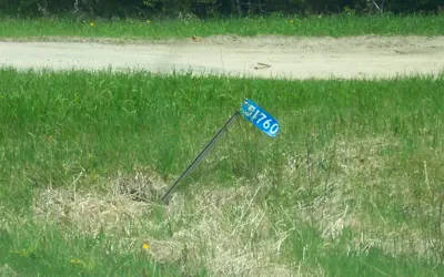 Damaged blue address number sign